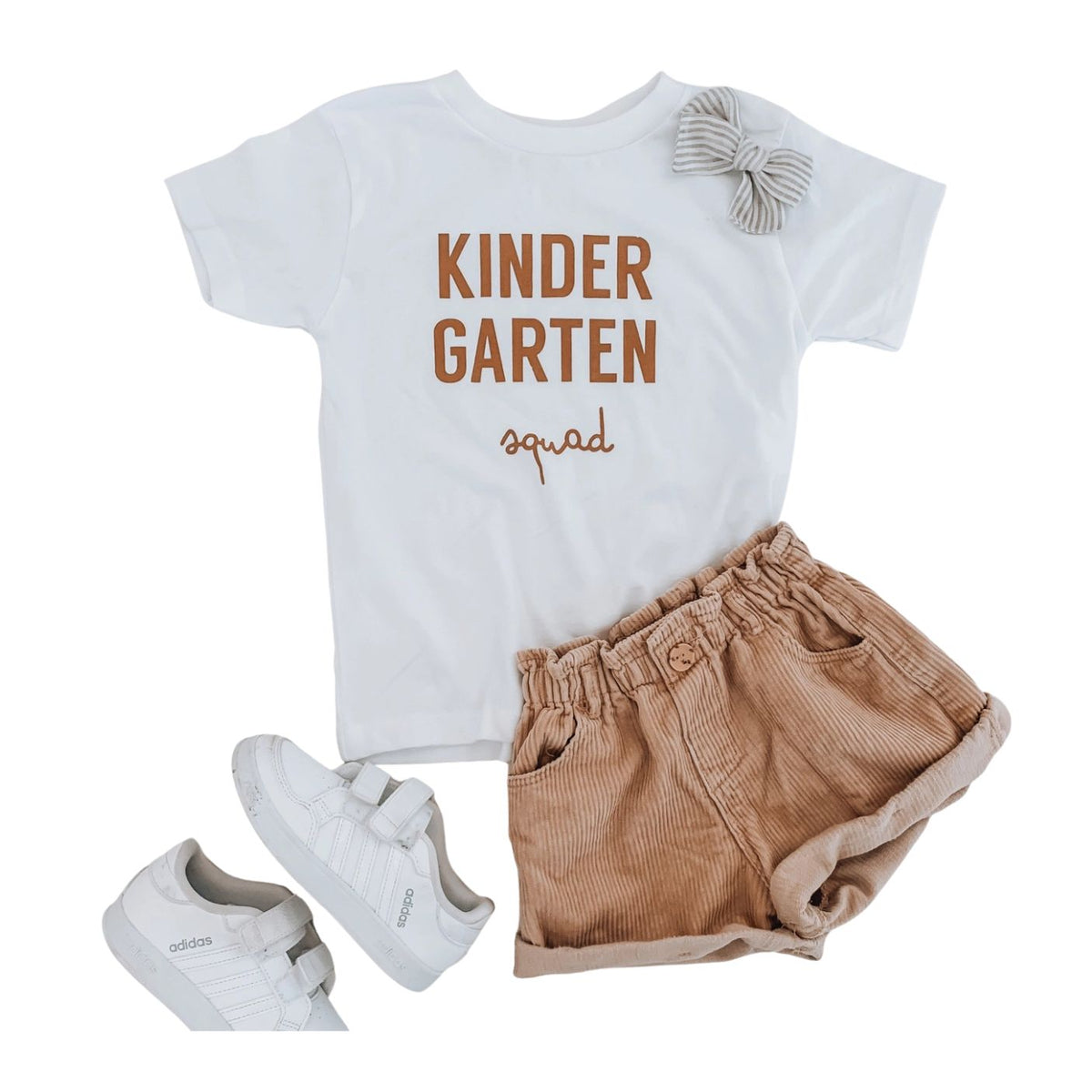 A white "Kindergarten Squad" graphic t-shirt with a matching hair and bow.
