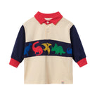 A children's long-sleeve polo shirt with a cream body, navy blue sleeves, and a red collar and cuffs. A horizontal navy band across the chest features colorful dinosaur silhouettes in blue, red, yellow, and green.
