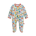 A baby footed one-piece sleeper with a colorful city bus and truck pattern on a white background, featuring orange-red trim on the collar and cuffs.