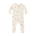 A baby footed sleeper in cream with a brown mushroom and leaf pattern, featuring a front zipper closure.