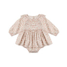 A baby long-sleeve romper in a light beige and pink floral pattern, featuring a ruffled collar and a gathered peplum waist, shown flat on a white background.