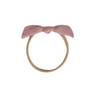 A dusty pink fabric bow headband with a tan elastic band, shown against a plain white background.