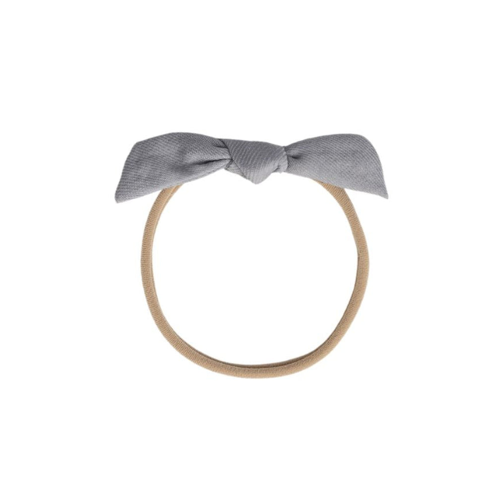 Two fabric headbands with bow details, one in beige with a light gray bow and the other in brown with a light gray bow, shown on a plain white background.