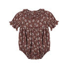 A baby romper in a dark brown color with a light beige floral pattern, featuring short ruffled sleeves and a ruffled neckline, shown against a plain white background.