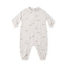 A baby long-sleeve footless one-piece jumpsuit in a warm off-white/cream color, featuring a delicate all-over print of small brown foxes and tiny blue birds. The jumpsuit has ribbed cuffs, a crew neck, and snap closures at the crotch.