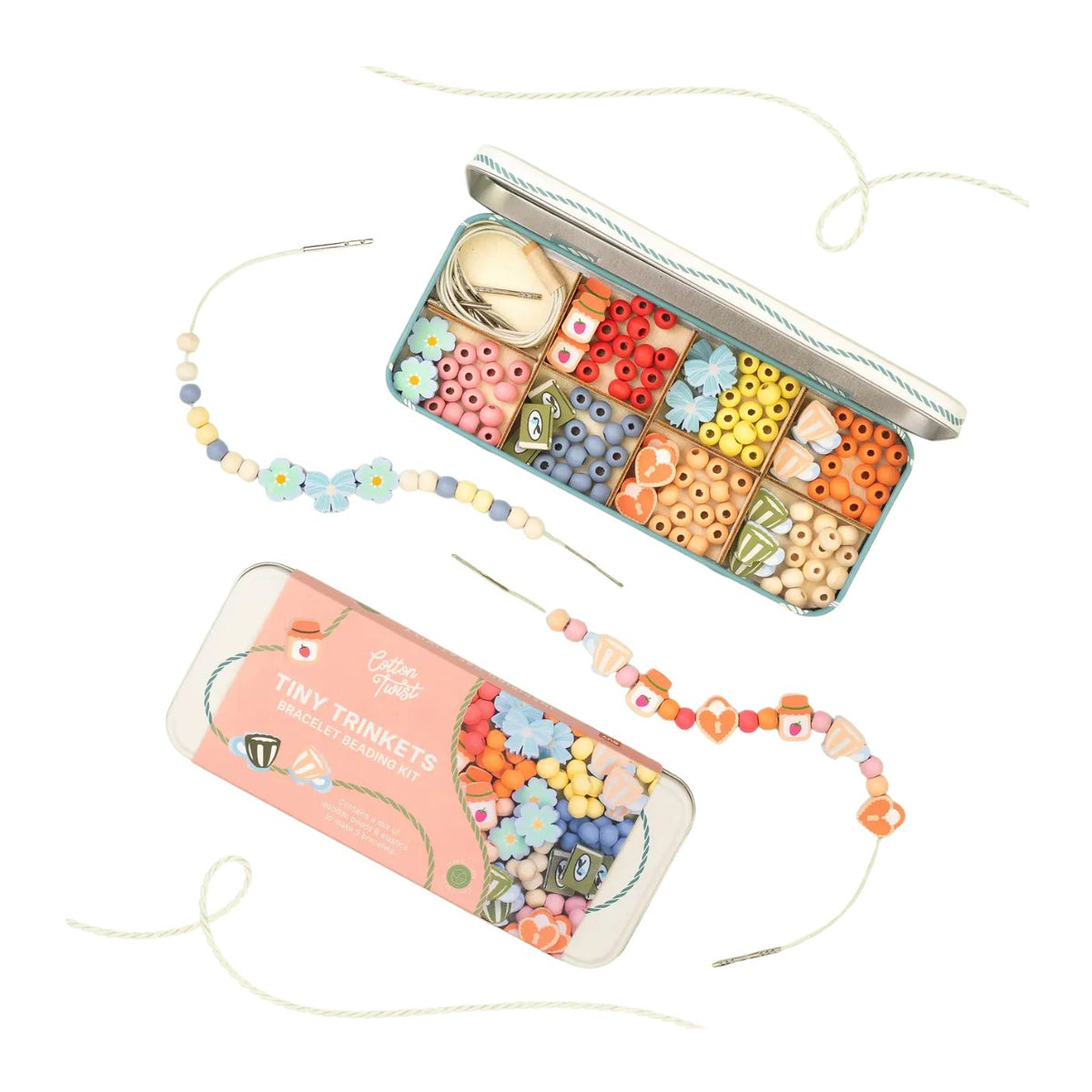 A craft kit shown in two views: one open tin displaying colorful wooden beads in compartments, and one closed tin labeled 'Cute Beads Tiny Trinkets Bead Set' showing the bead assortment through a clear window. Beads are strung on thin cords and arranged around the tins on a white background.