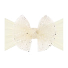 An off-white tulle hair bow with silver glitter accents, displayed on a matching off-white ribbon against a solid white background.