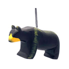 A handcrafted wooden bear ornament painted primarily in black with a bright yellow snout and subtle green painted accents on its back and side, hanging by a black string against a plain white background.