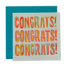 A square congratulations card with a light gray background and bold, raised multicolor lettering that reads 'CONGRATS! CONGRATS! CONGRATS!'. A teal envelope is partially visible behind the card on a white background.