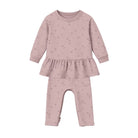 A baby girl's two-piece outfit in dusty pink, featuring a long-sleeve top with a ruffled hem and matching leggings, both decorated with a subtle star pattern, shown on a plain white background.