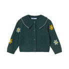 A dark green knit cardigan sweater for toddlers, featuring a textured cable-knit pattern, a wide pointed collar with a white scalloped edge, button closure, and embroidered daisy motifs on the front and sleeves.