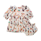 A baby girl's two-piece outfit set consisting of a long-sleeve dress and matching bloomers, featuring an all-over print of rabbits, balloons, and gifts on a cream-colored background.