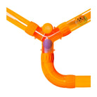 An orange plastic Y-shaped tube play structure with a curved elbow section and a small purple ball visible inside, isolated on a white background.