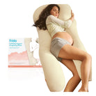 A pregnant woman reclines on a cream-colored U-shaped body support pillow, with the product packaging box visible to the left. The pillow is branded 'frida' and is shown against a clean white background.