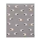 A square gray textile item, likely a blanket or towel, featuring a repeating pattern of stylized sheep in cream, white, and black.