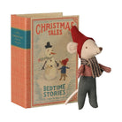 A vintage-style children's book titled "Christmas Tales: Bedtime Stories" with an illustrated snowman and child on the cover, shown next to a small plush mouse doll wearing a red hat, plaid shirt, and gray pants. The book has an orange textured cover with a teal band, and the doll is posed in front on a plain white background.