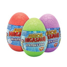 Three Junior Megasaur Mystery Egg toys in red, green, and purple, arranged together on a plain white background.