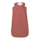 A sleeveless baby sleep sack in a dusty rose color , featuring a diagonal zipper and a small black tag near the bottom left hem, shown against a plain white background.