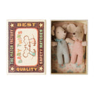 Two Maileg baby mice lying side-by-side inside an open matchbox bed, wearing patterned onesies and matching neck bows, next to the decorative matchbox lid labeled "Best Quality Baby Twins."
