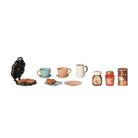A product photo on a white background showing the Maileg Waffle Set, including a black mini waffle maker with heart-shaped waffles, two cups, two saucers, two plates, a pitcher, jars of chocolate spread and strawberry jam, and a hot chocolate tin.