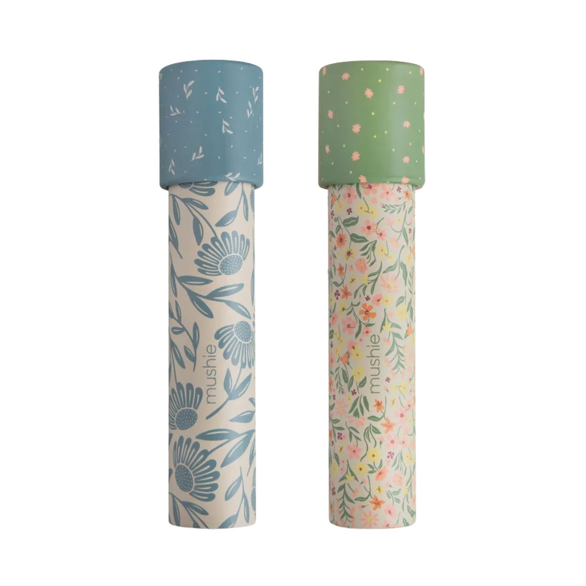 Two Mushie paper kaleidoscopes standing vertically against a white background, featuring the Floral Combo pattern with green caps and botanical floral illustrations.