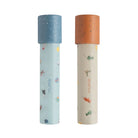Two Mushie paper kaleidoscopes standing vertically against a white background, featuring the Space and Dinosaurs pattern with blue and orange caps.