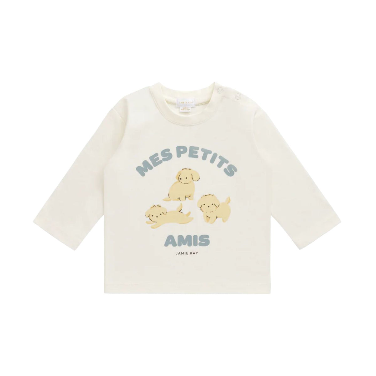 An off-white long-sleeve baby t-shirt featuring a cute graphic of three yellow puppies and the text 'MES PETITS AMIS' in blue-gray, with 'JAMIE KAY' printed below.
