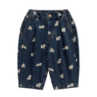 Dark blue denim shorts with an all-over white dog print, featuring a button fly and front pockets, shown flat on a white background.