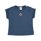 A navy blue short-sleeve t-shirt for kids, featuring a small circular red and white nautical emblem on the left chest and decorative buttons on the collar and lower hem, shown on a plain white background.