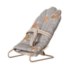 Gray baby bouncer with floral patterns on a white background