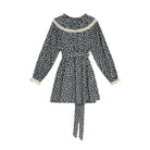 A long-sleeve belted dress with a small white floral print on a dark navy background, featuring a wide cream-colored collar and matching cream cuffs.