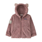 A dusty rose pink Patagonia fleece zip-up hoodie with bear ears on the hood, a front zipper, and a Patagonia logo patch on the left chest.