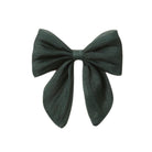 A dark forest green bow made of lightweight, semi-sheer fabric, photographed against a solid white background.