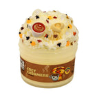 A novelty squishy toy shaped like a frosted cup of coffee, with whipped cream-like texture, a brown label reading 'COZY CASHMERE,' and autumn-themed decorative accents on top.