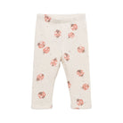 A pair of baby leggings in a light cream color, featuring an all-over print of pink ladybugs with brown details.
