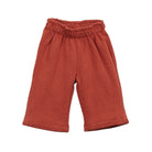 A pair of terracotta-colored knit shorts with an elastic waistband and ribbed cuffs, shown against a plain white background.