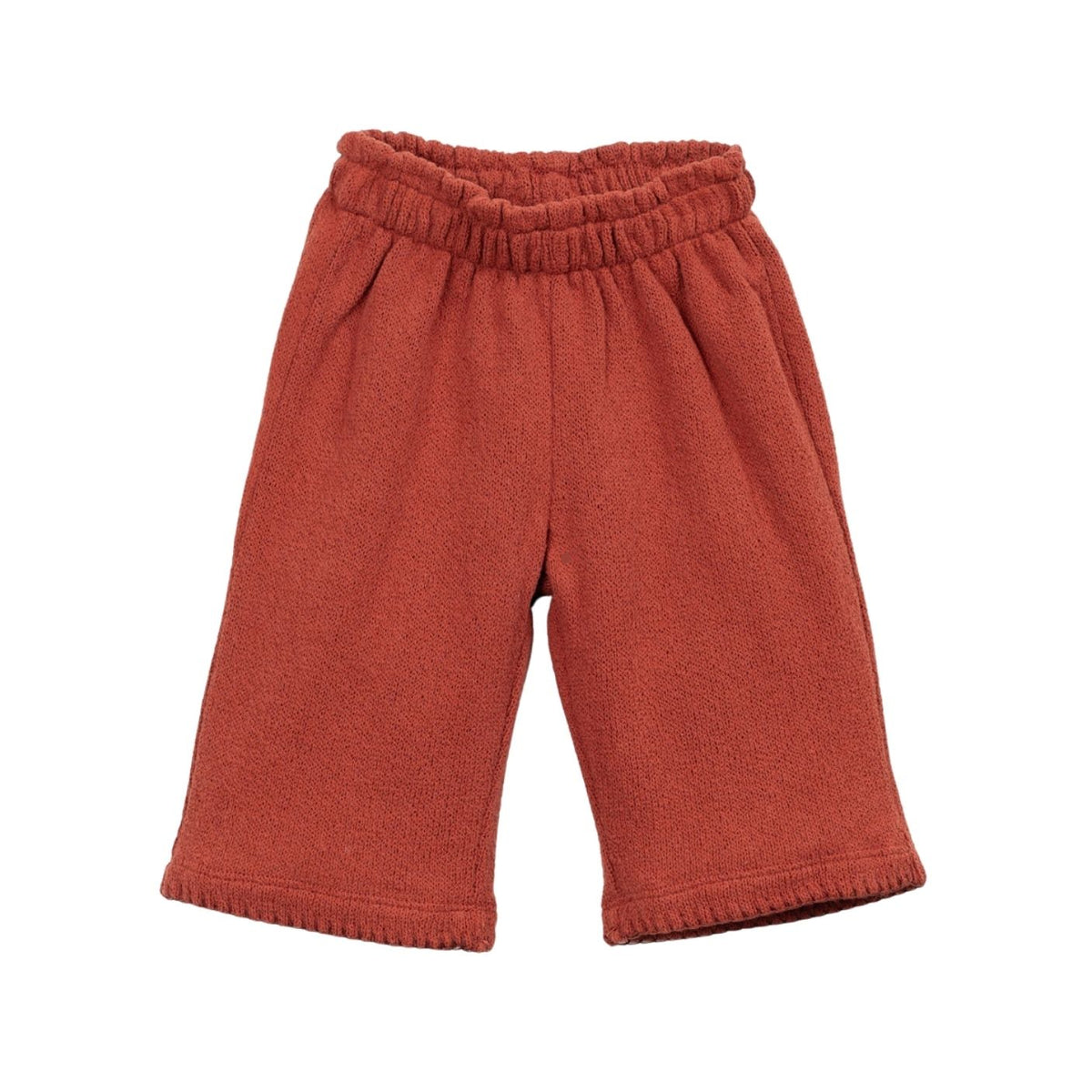 A pair of terracotta-colored knit shorts with an elastic waistband and ribbed cuffs, shown against a plain white background.