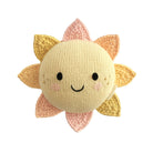 A knitted sun plush toy with a round cream-colored face, black embroidered eyes and smile, and soft yellow, peach, and pink rays, shown on a plain white background.