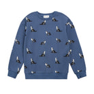 A blue crewneck sweatshirt featuring an all-over print of black and white dogs, shown flat against a plain white background.