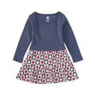 Navy blue long-sleeve dress with a patterned skirt on a white background