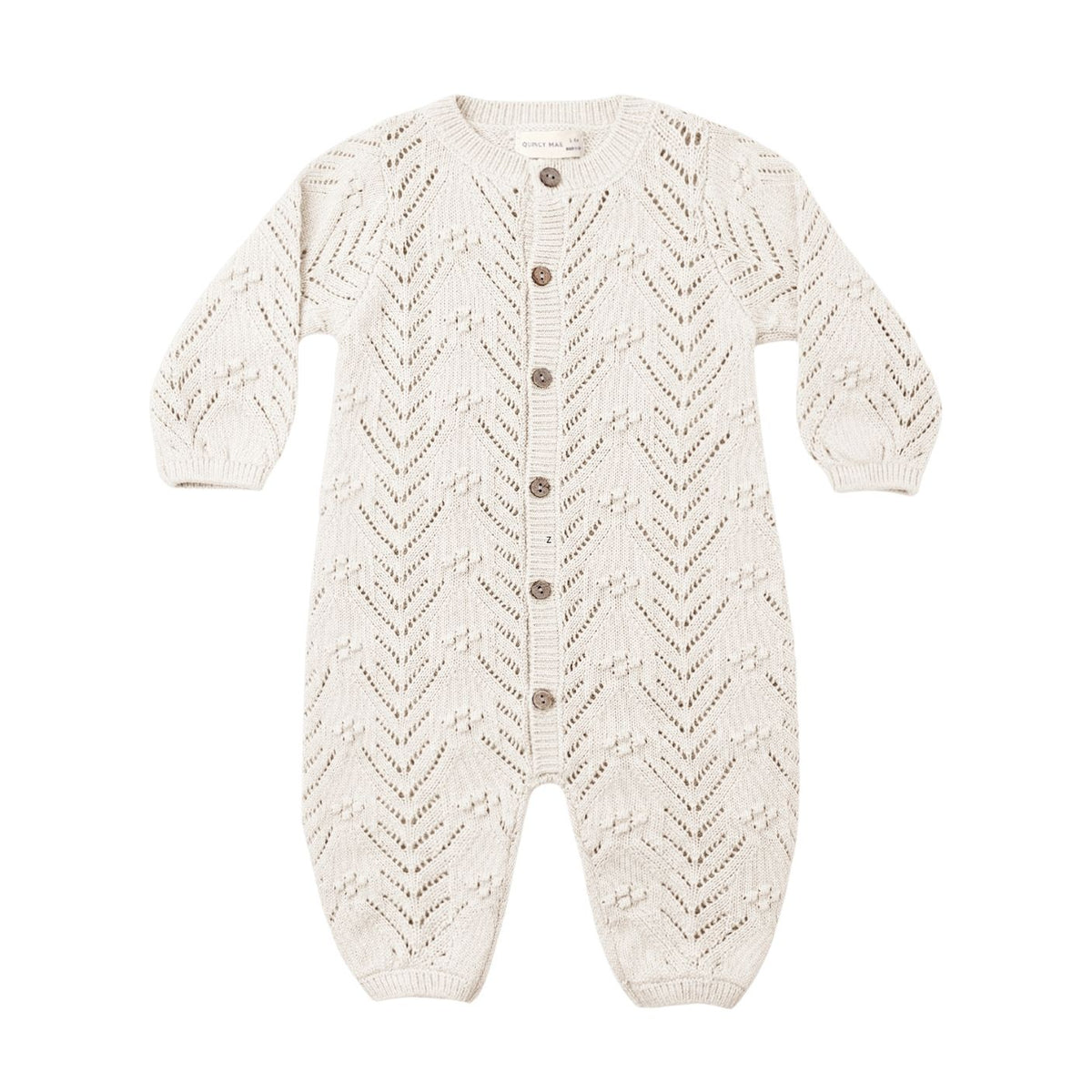 An off-white knit baby romper with a textured chevron pattern and brown buttons down the front, shown on a plain white background.
