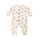 A long-sleeve baby jumpsuit in cream-colored muslin fabric, featuring an all-over print of small brown and tan acorns with tiny leaves. The jumpsuit has a snap-button closure down the front and is photographed flat against a solid white background.