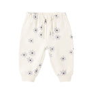 Off-white baby jogger pants with a small gray and purple daisy print, featuring an elastic waistband with a drawstring and ribbed ankle cuffs.