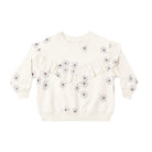 An off-white long-sleeve children's sweatshirt featuring a ruffled yoke and an all-over daisy print with gray petals and small brown centers, shown against a plain white background.