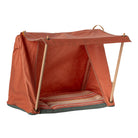 An orange-brown canvas dog crate with a pop-up wooden frame and a striped cushion inside, shown on a plain white background.