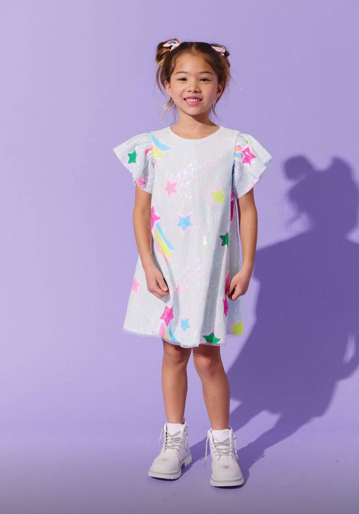 Young girl wearing a colorful dress with a plain purple background