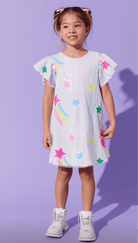 Young girl wearing a white dress with colorful star patterns against a purple background