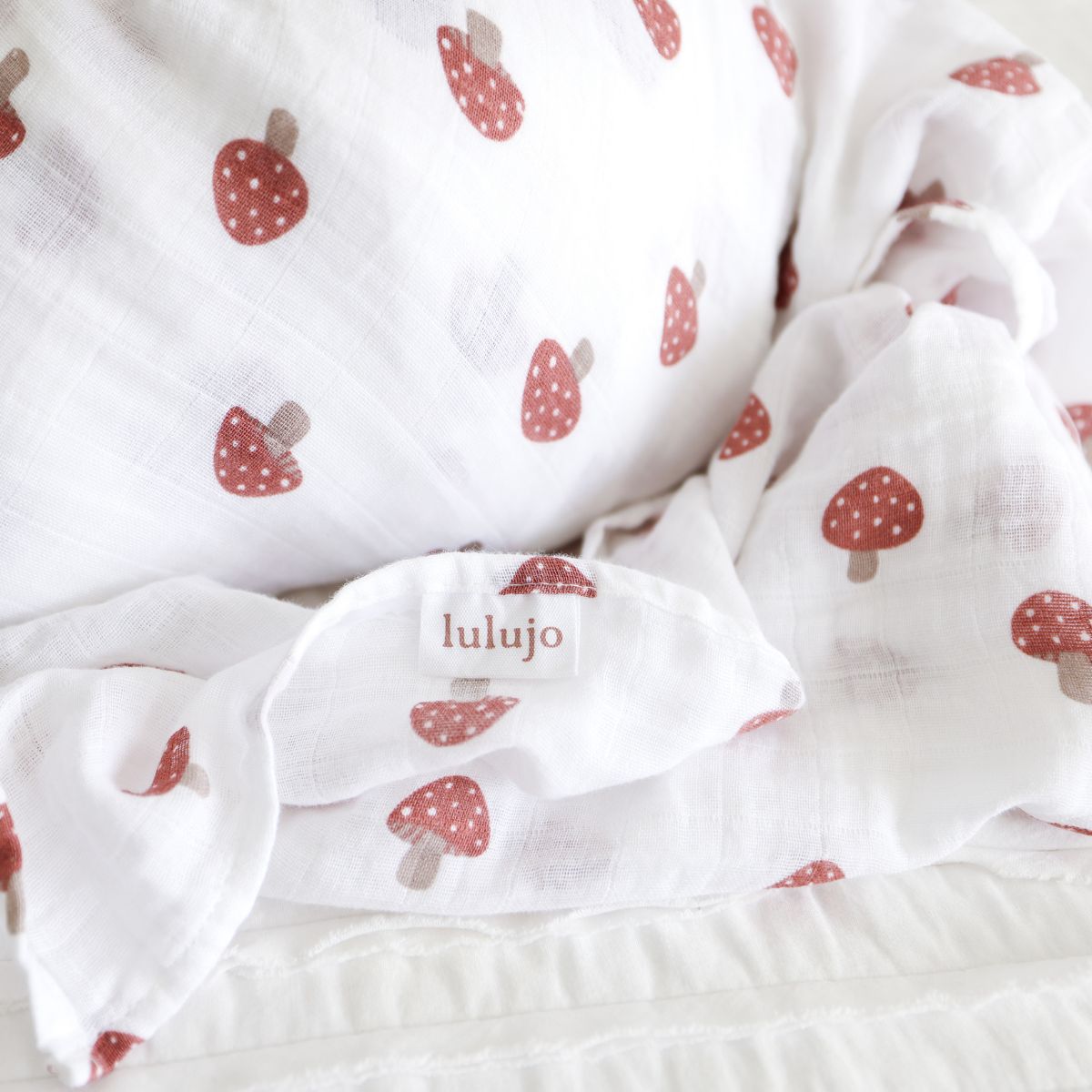 White muslin cloth with red mushroom pattern and 'lulujo' branding.