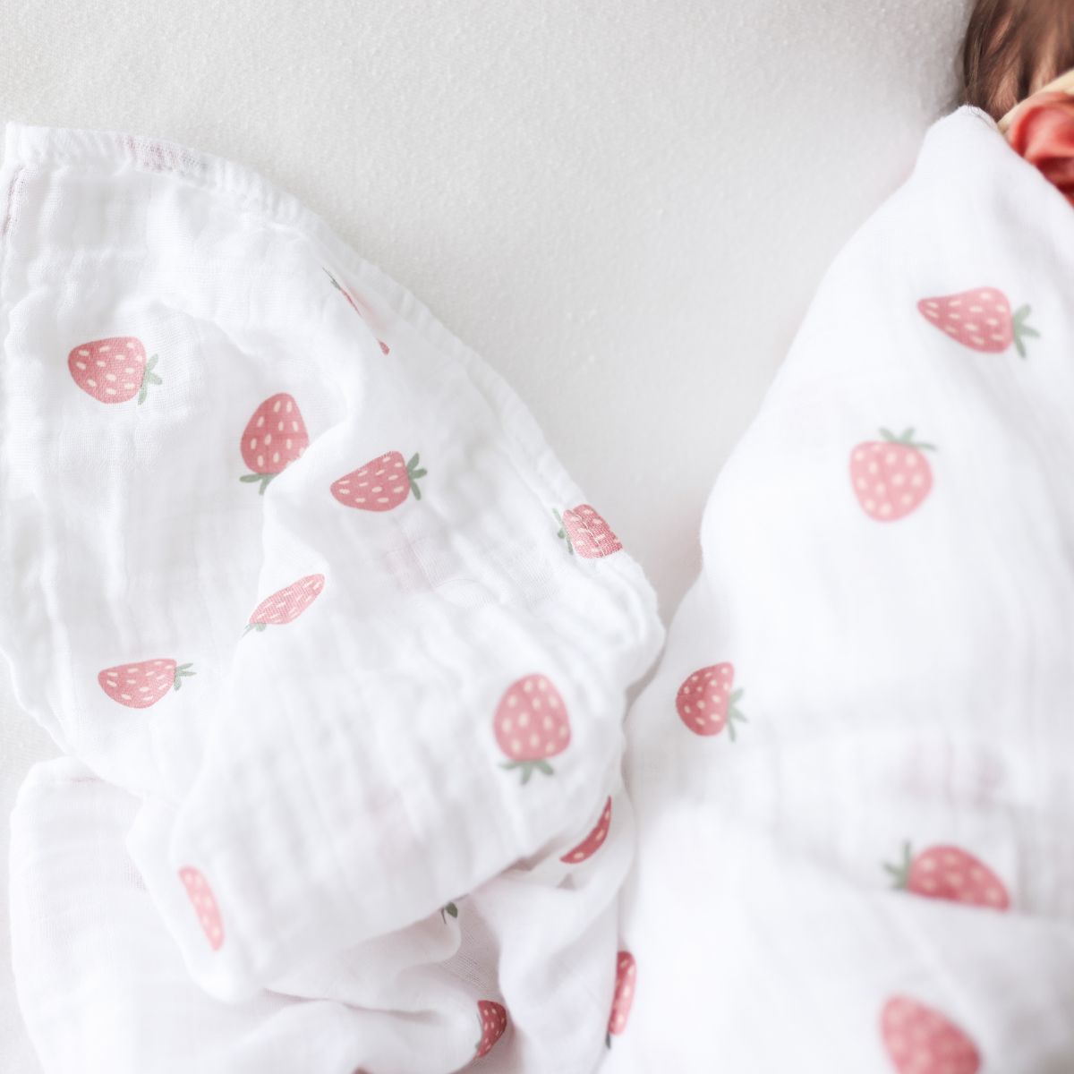White fabric with strawberry pattern on a plain background