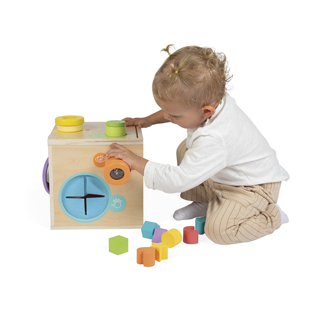 Child playing with a wooden shape sorting toy on a white background